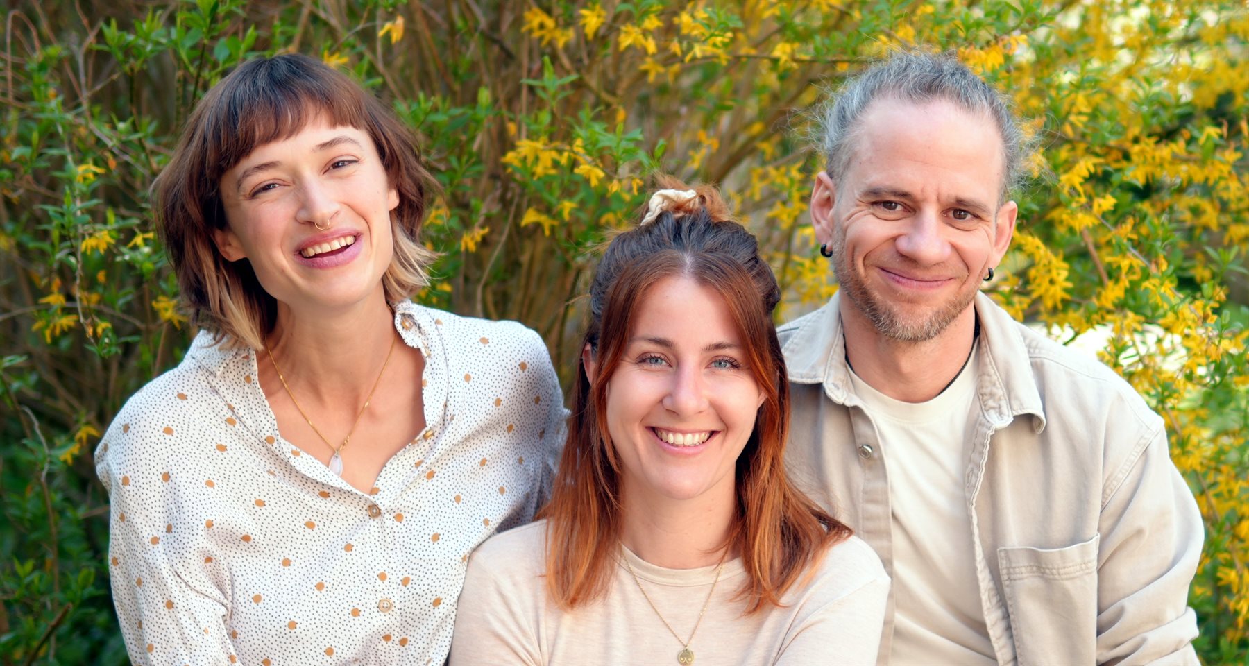 Ronja Junicke, Teresa Hierenbach und Markus Castro vor einer bluehenden Forsythie