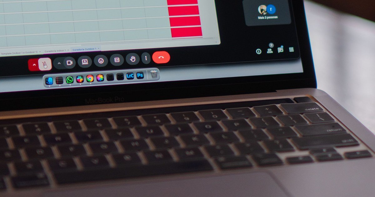 MacBook Pro mit Videokonferenz-Steuerung, Dock-Symbolleiste und Tabellenkalkulation im Hintergrund auf dem Bildschirm.